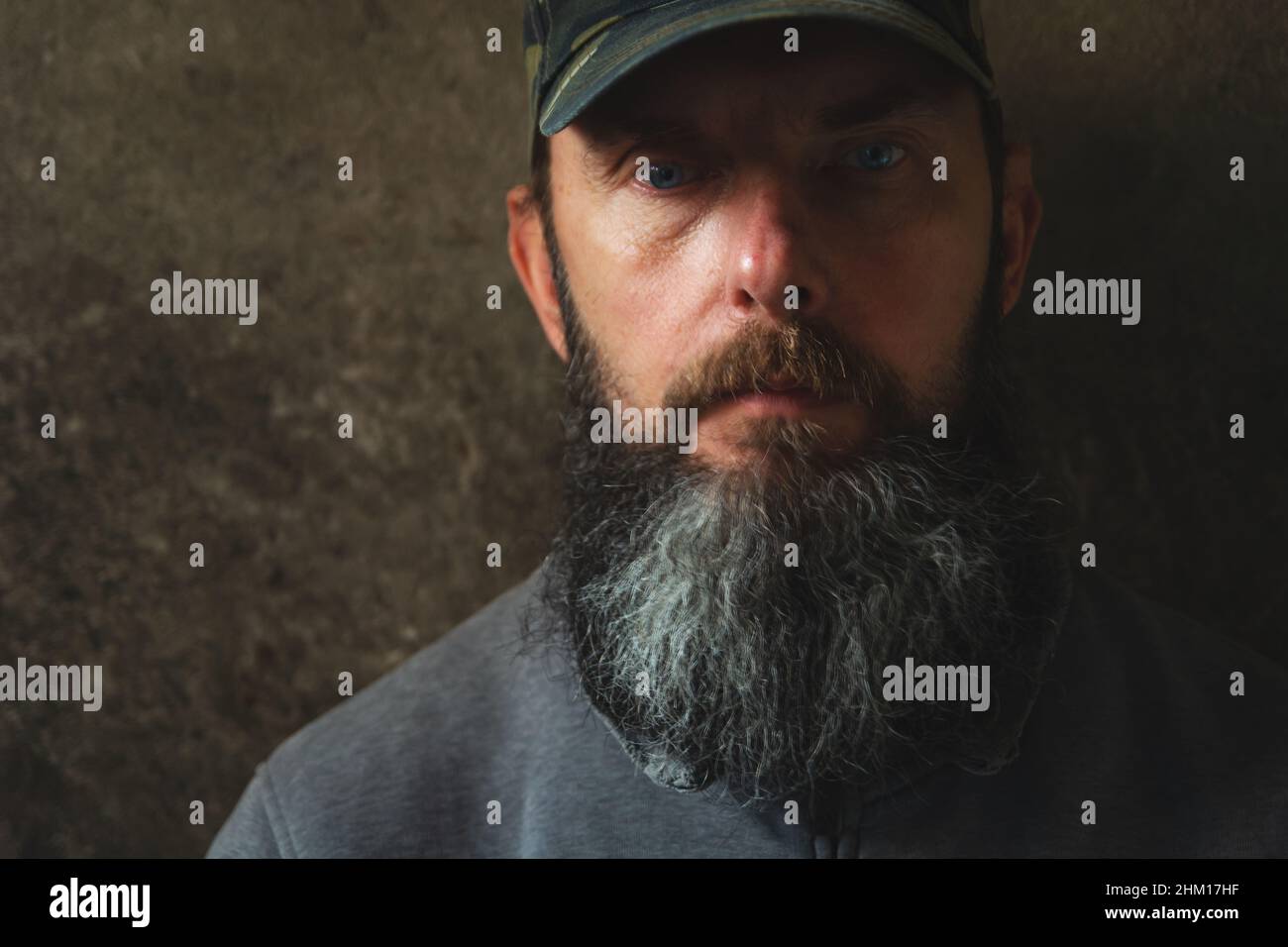 Un hombre con una barba larga en una gorra de béisbol, retrato masculino Foto de stock