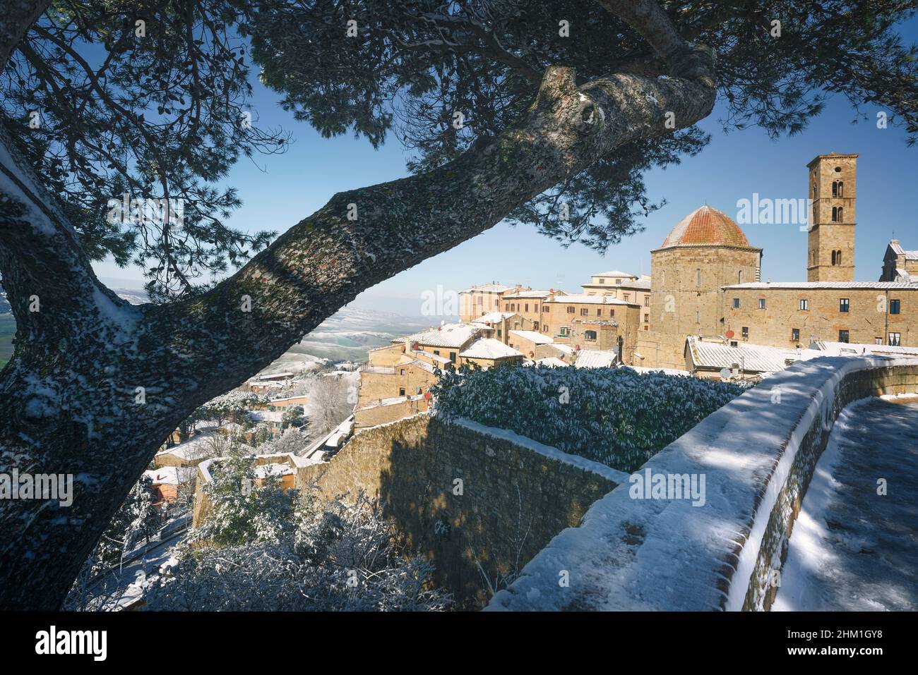 Volterra ciudad nevada en invierno y un árbol. Pisa provincia, Toscana región, Italia, Europa. Foto de stock