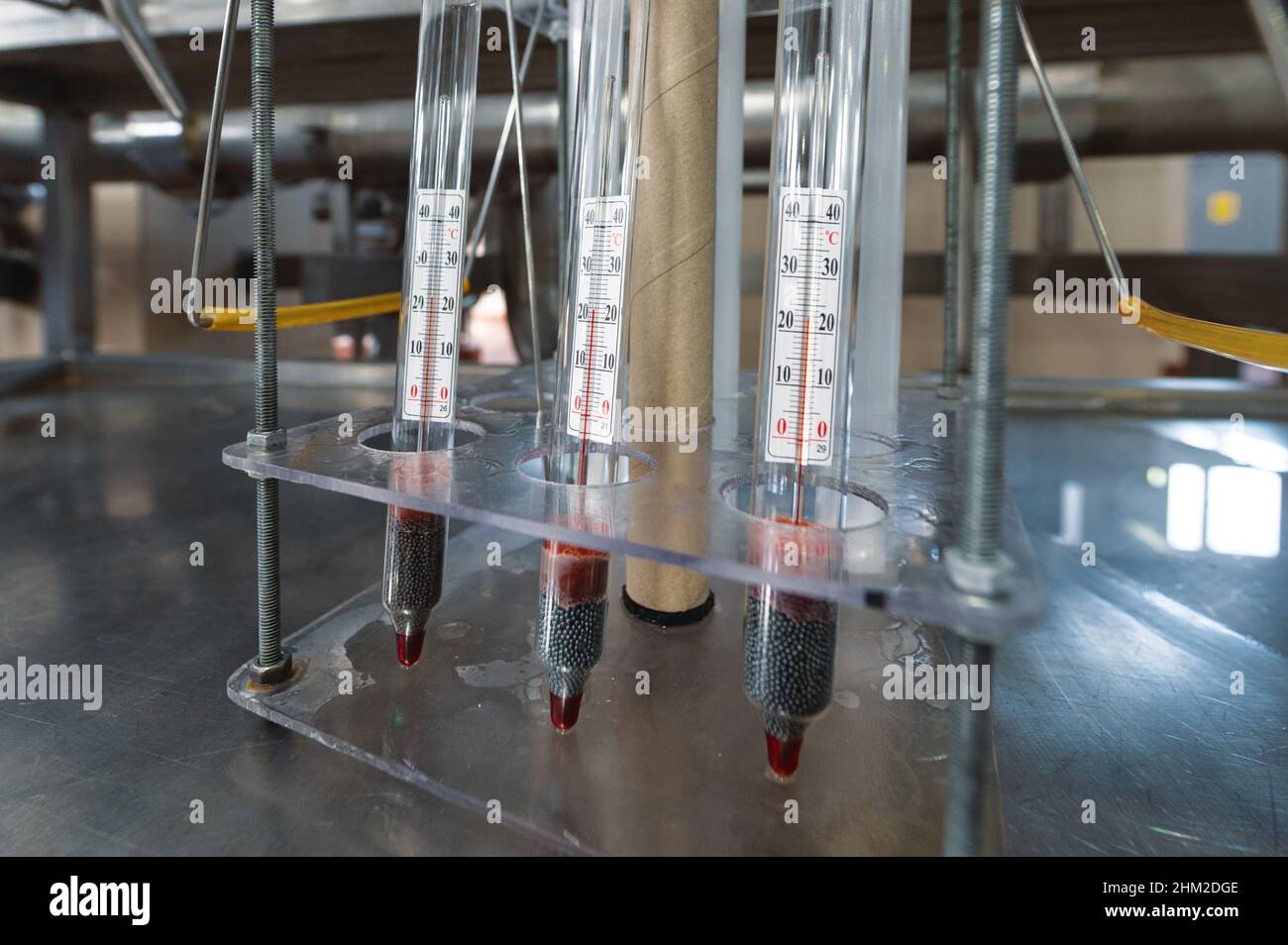 Tres termómetros de laboratorio de mercurio están en un soporte