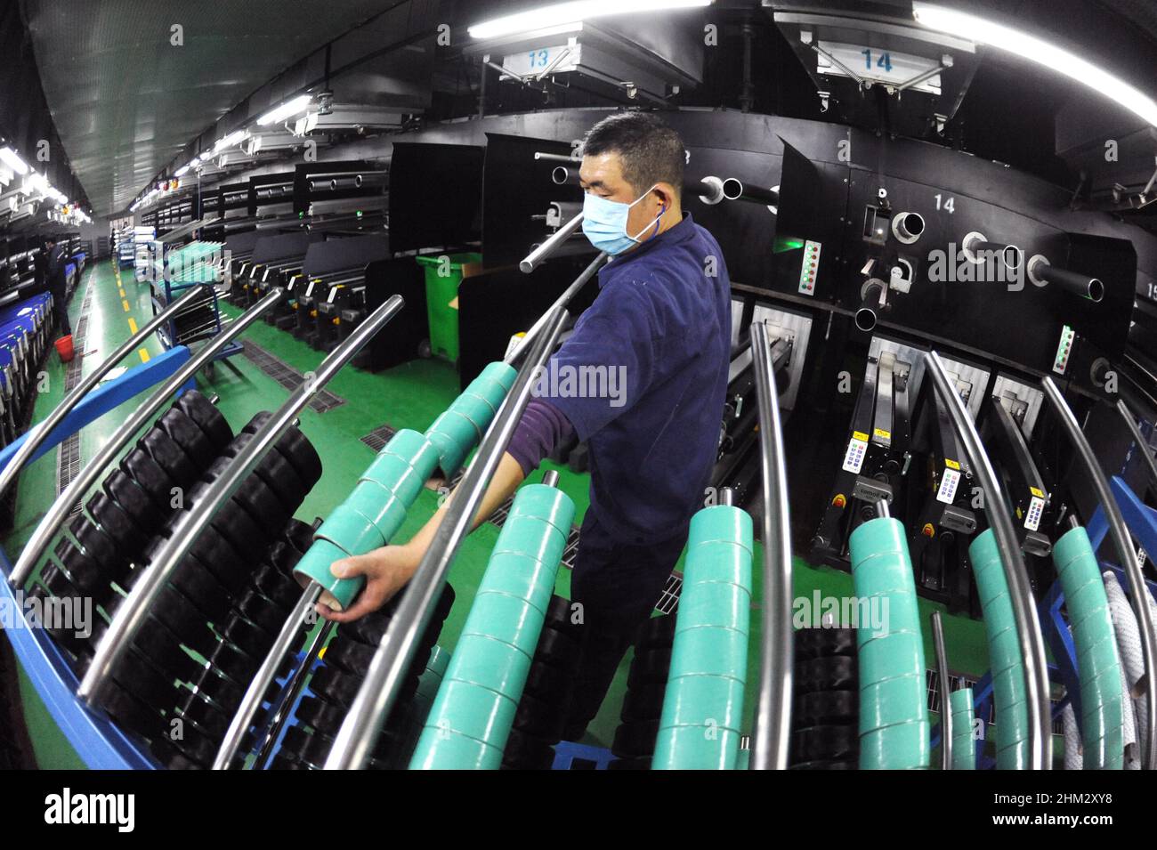 LIANYUNGANG, CHINA - 7 DE FEBRERO de 2022 - Un trabajador procesa productos de spandex en el taller de producción de duzhong Spandex en Lianyungang Economic and Techvol Foto de stock