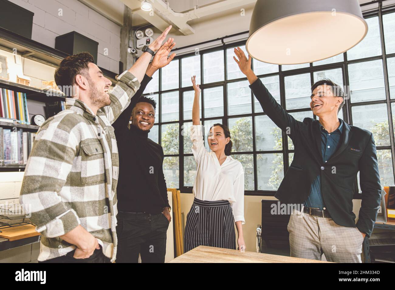 grupo de empleados de la oficina de negocios mezcla carrera alegre alegría de levantar la mano juntos para el proyecto de acabado exitoso hecho concepto Foto de stock