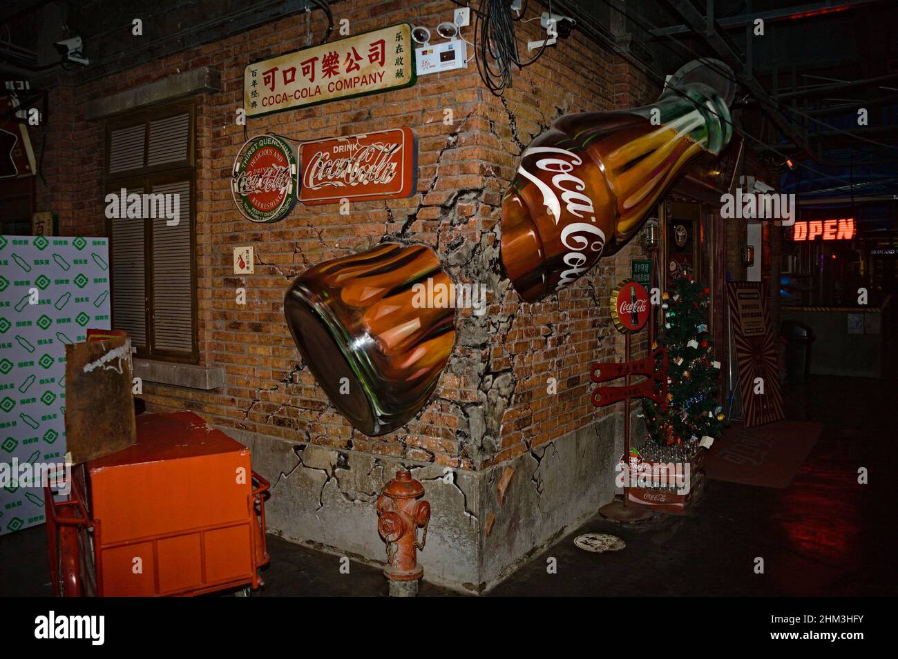 Botella grande de Coca Cola incrustada en pared de ladrillo en Shenzhen, China Foto de stock