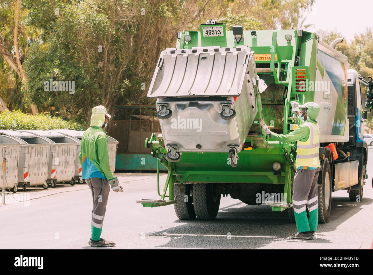 Dubai, EAU, Emiratos Árabes Unidos - 25 de mayo de 2021: Trabajador de  reciclaje municipal de camiones de recolección de basura que carga residuos  y papelera. Hombres Los trabajadores cargan A Fotografía