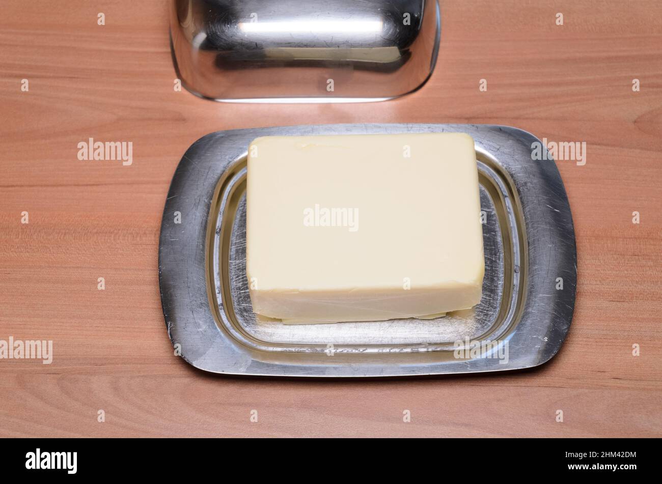 Plato de mantequilla de metal en el escritorio de madera en la cocina, vista desde arriba Foto de stock