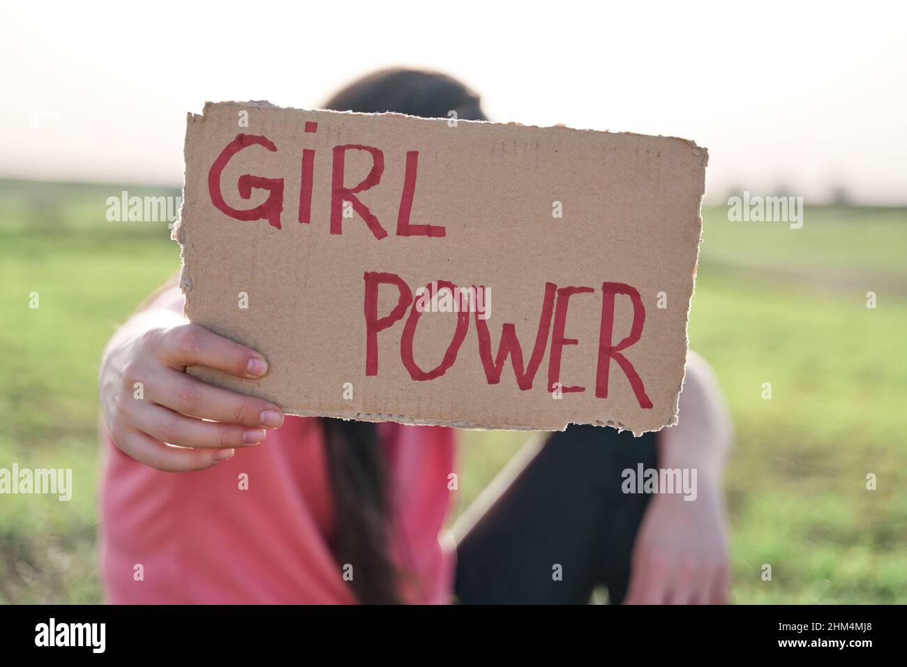 Mujer sosteniendo un cartón reciclado con la inscripción chica poder. Concepto de feminismo. Foto de stock