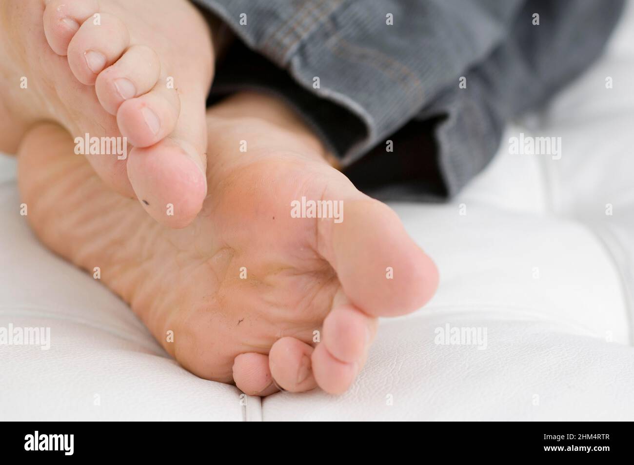 Vista de sección baja de los pies sucios De una persona en la cama, Crédito:Photoshot Creative / Stuart Cox / Avalon Foto de stock