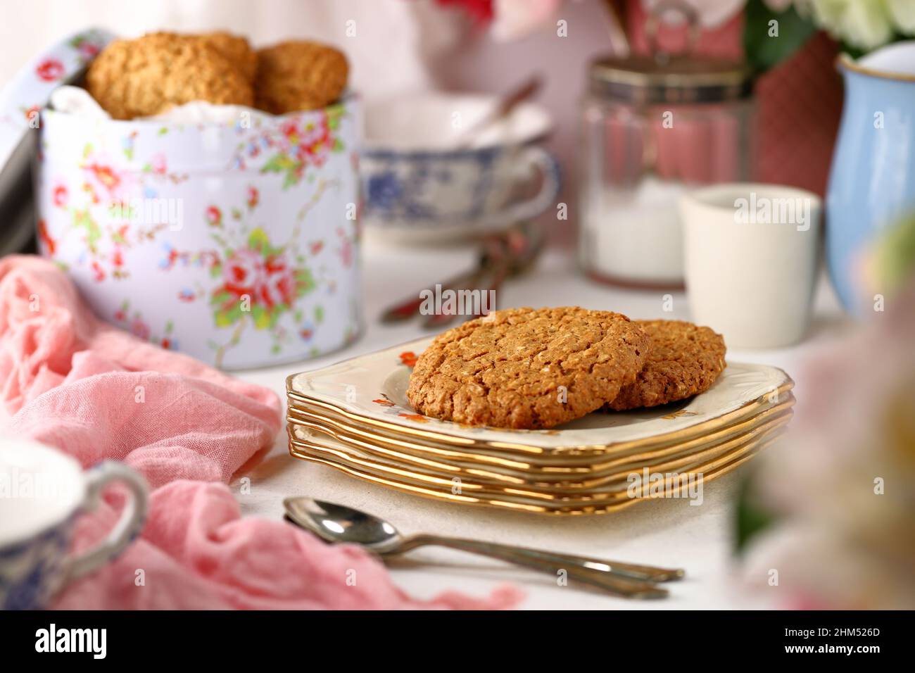 Juego de mesa con vajilla vintage para el tradicional té inglés de la tarde con una lata de galletas y galletas caseras en un plato Foto de stock