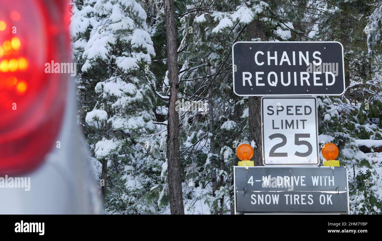 Cadenas o neumáticos de nieve requeridos señal de tráfico, montañas  carretera de invierno, Yosemite bosque nevado, California USA. Advertencia  o precaución por carretera con hielo, seguridad durante las nevadas para el  transporte.