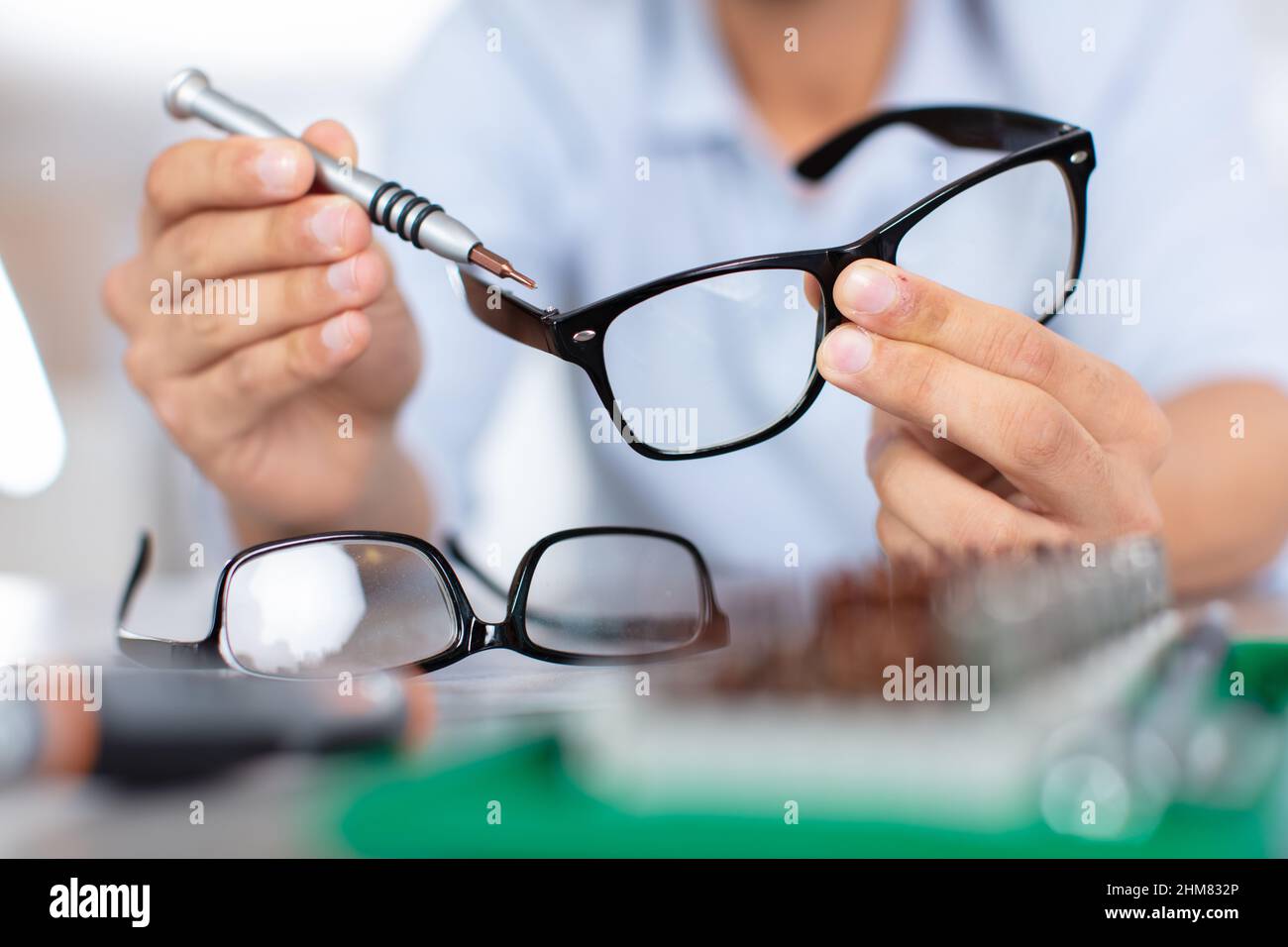 óptica midiendo y preparando gafas en almacén óptico Foto de stock