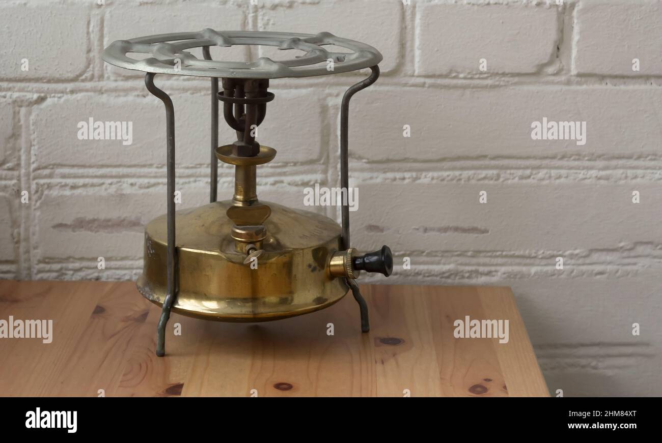 antigua estufa de queroseno en el fondo de una pared de ladrillo blanco en  una mesa de madera Fotografía de stock - Alamy
