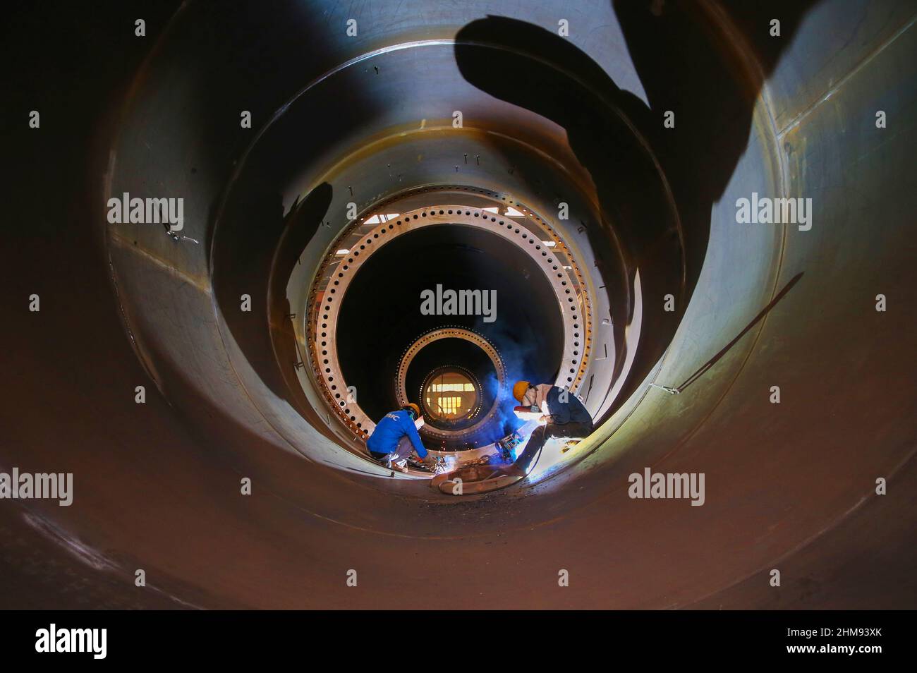 LIANYUNGANG, CHINA - 8 DE FEBRERO de 2022 - Un trabajador produce una torre de viento en un taller de Chongshan Wind Equipment Company en Lianyungang Economic and T Foto de stock