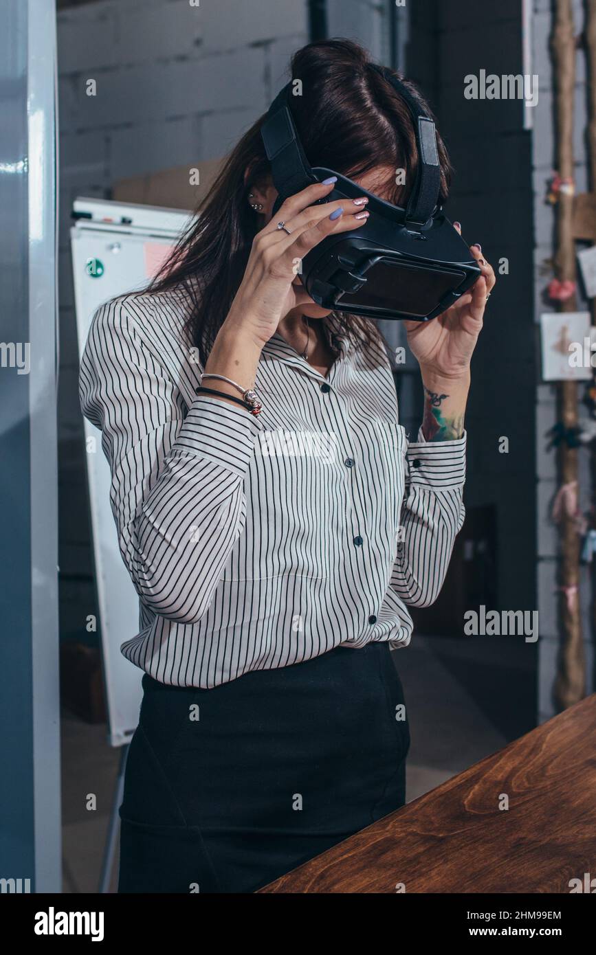 Trabajadoras de oficina que se divierten en el trabajo viendo vídeo 3D en gafas VR, la mujer tocando algo experimentando la realidad virtual. Foto de stock