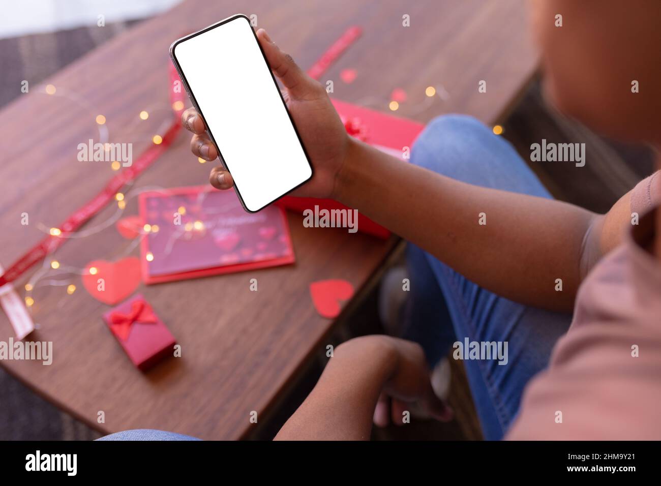 Joven afroamericano que utiliza el teléfono inteligente con espacio en blanco, espacio de copia Foto de stock