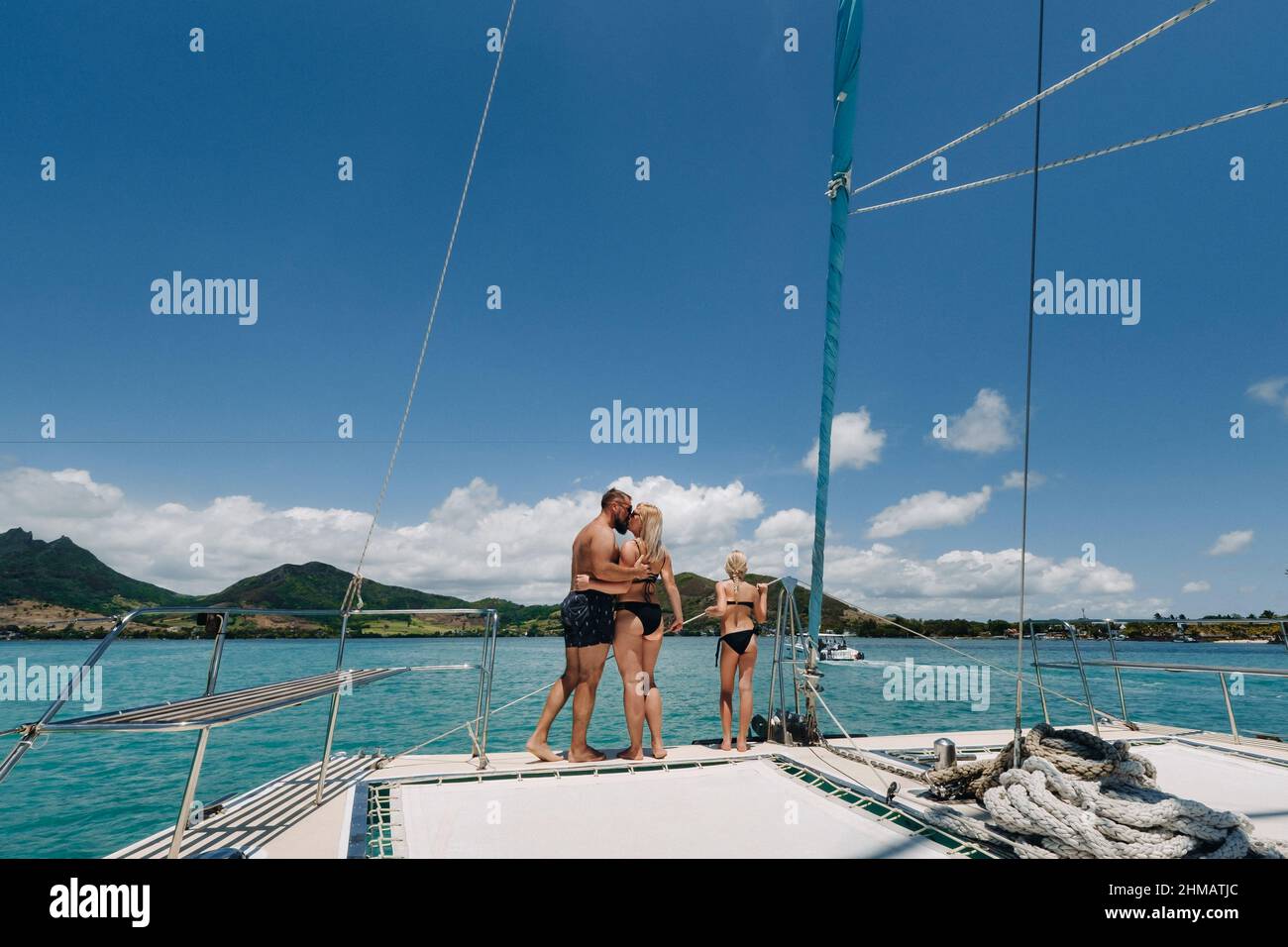 Una familia feliz en trajes de baño se encuentra en un catamarán en el  Océano Índico. retrato de una familia en un yate en el arrecife de coral de  la isla de