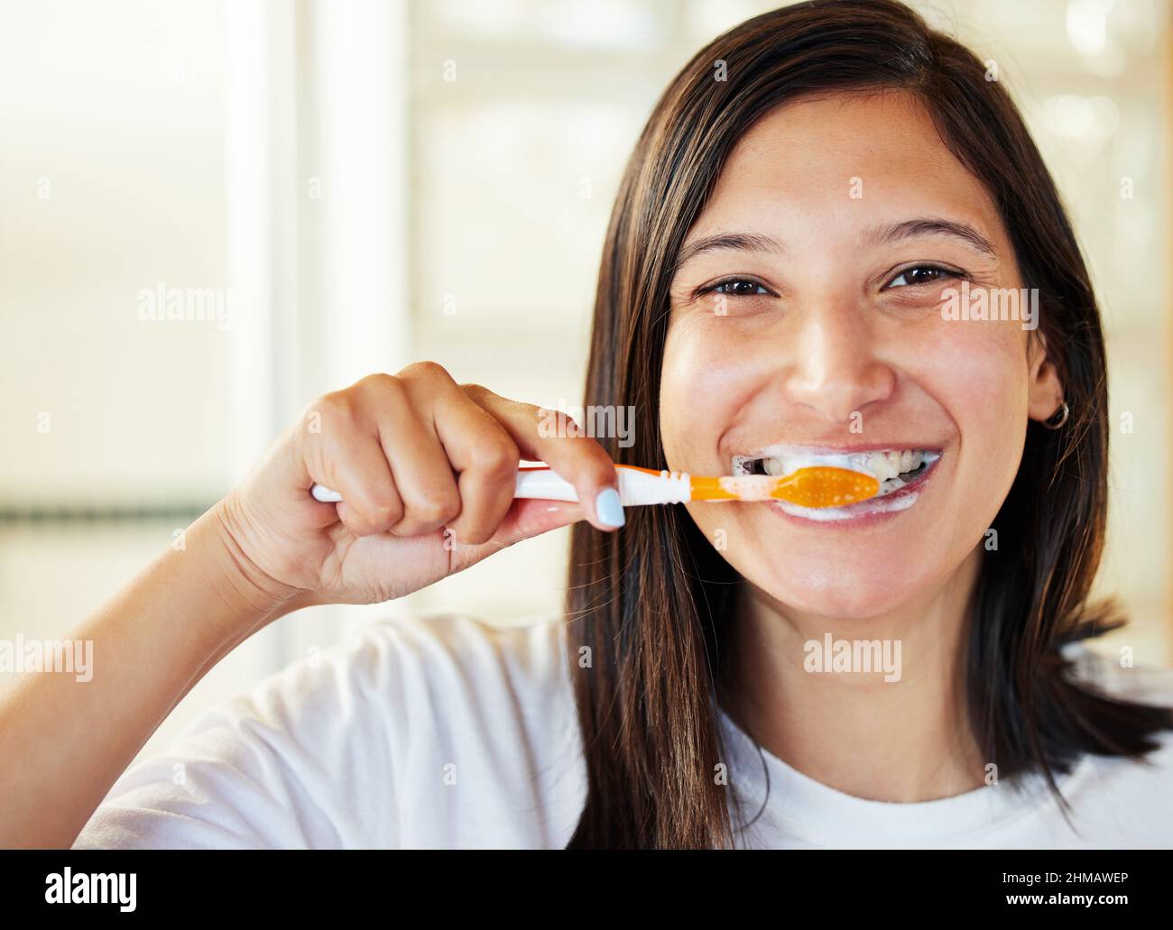 Nadie se lamenta cepillarse los dientes. Primer plano de una hermosa mujer joven cepillándose los dientes. Foto de stock