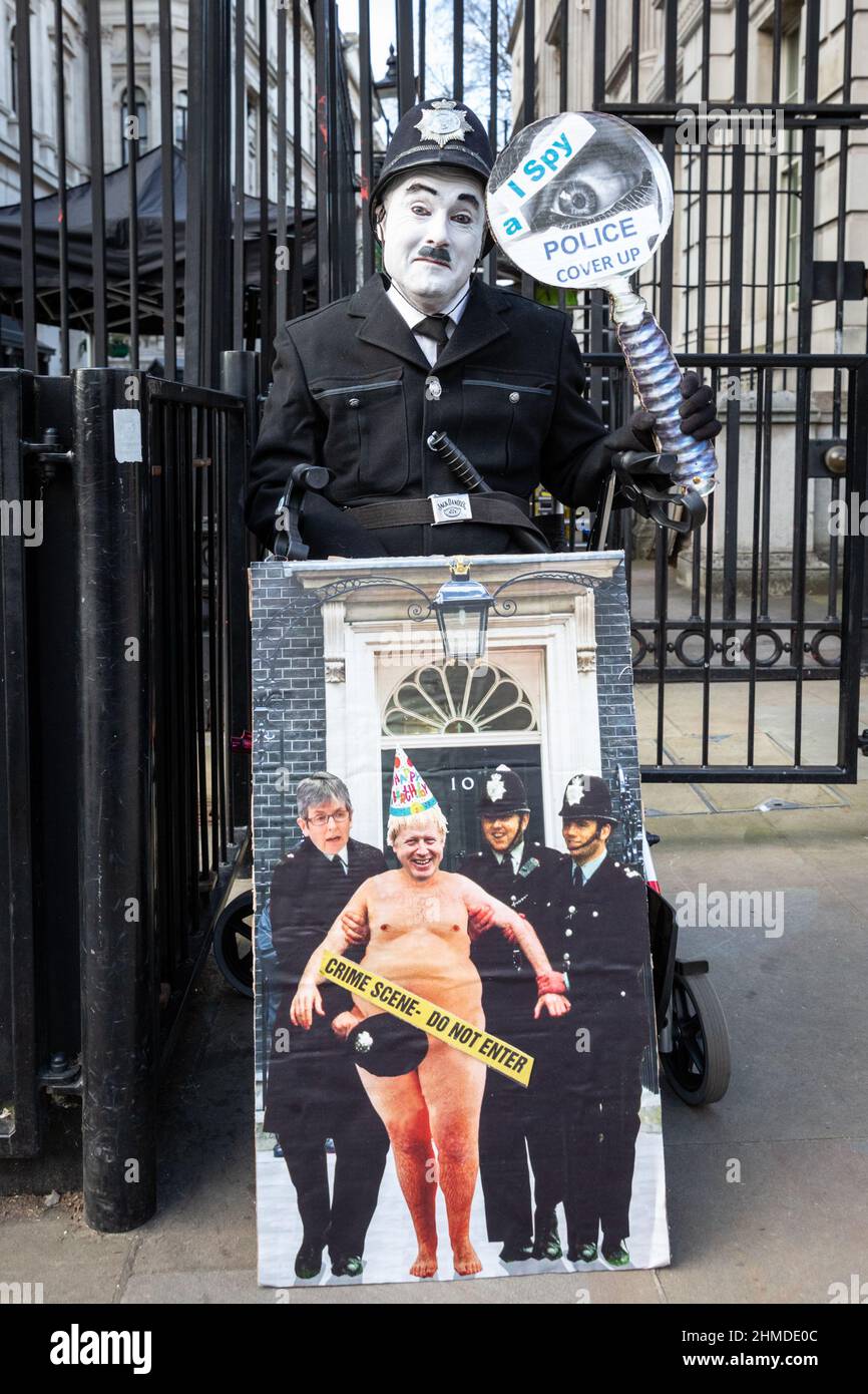 Londres, Reino Unido. 09th Feb, 2022. Un manifestante en Charlie Chaplin maquillaje y uniforme de policía fuera de Downing Street sostiene un cartel lamentando un 'encubrimiento de policía'. Crédito: Imageplotter/Alamy Live News Foto de stock