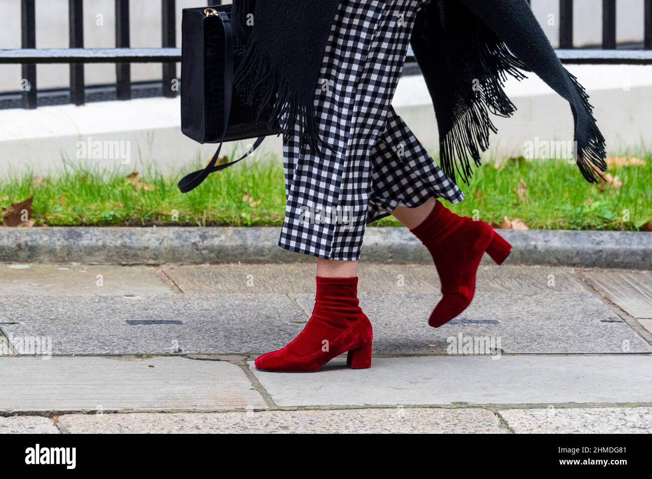 Londres, Reino Unido. 9 de febrero de 2022. Un visitante no identificado llega a Downing Street, trayendo un sentido de la moda con calzado rojo llamativo y pantalones de cuadros blancos y negros. Crédito: Stephen Chung / Alamy Live News Foto de stock