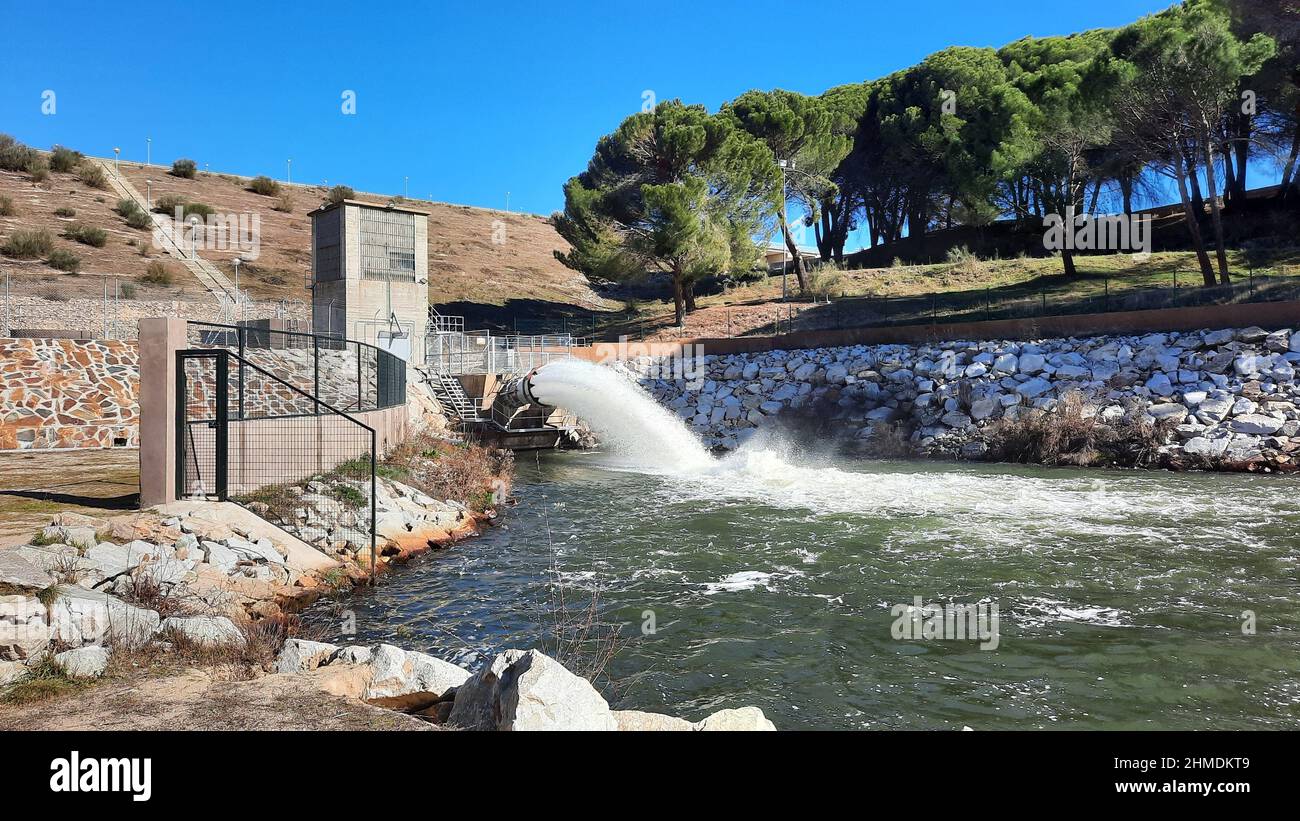Embalse El Pardo, en la Comunidad de Madrid, expulsando agua al río Manzanares. Pinos en el fondo, en España. Europa. Horizontal Foto de stock