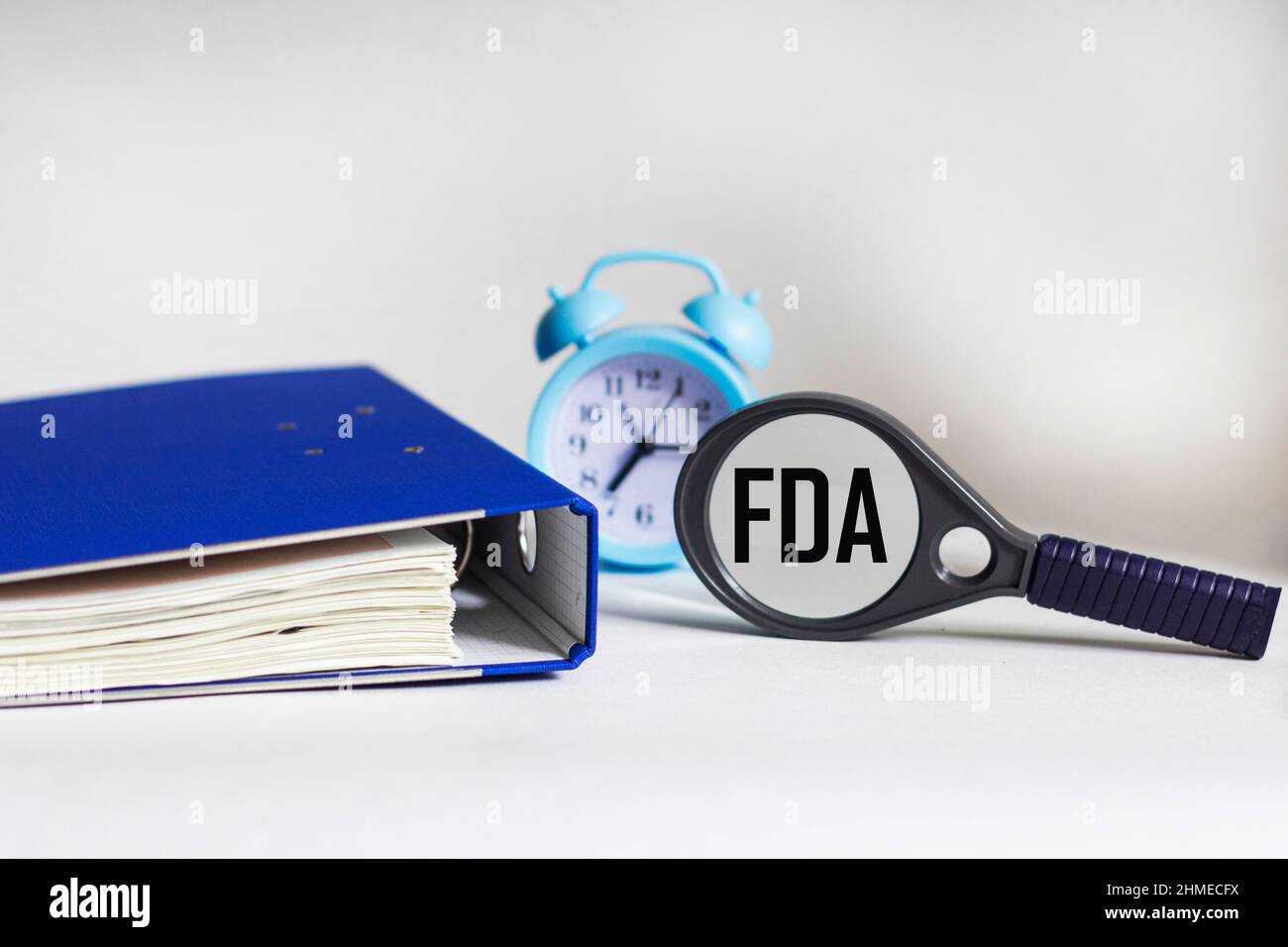 Concepto de la FDA. Concepto de la Administración de Alimentos y Medicamentos. Lupa de cristal, plegadora y reloj Foto de stock