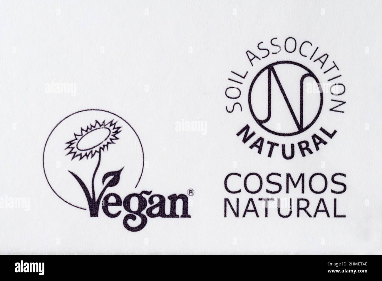 Logotipos de certificación veganos y Cosmos Natural sobre cosméticos. Foto de stock