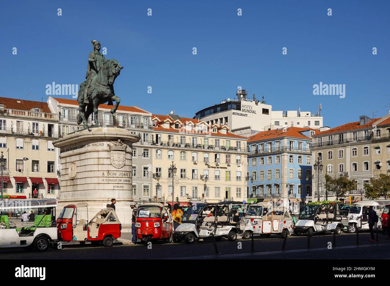 Lisboa, Portugal - 17 2021 de noviembre: Los conductores de tuk tuk esperan a los turistas por la estatua Dom Joao I en la plaza Figueira en el centro histórico de Lisboa en A. Foto de stock