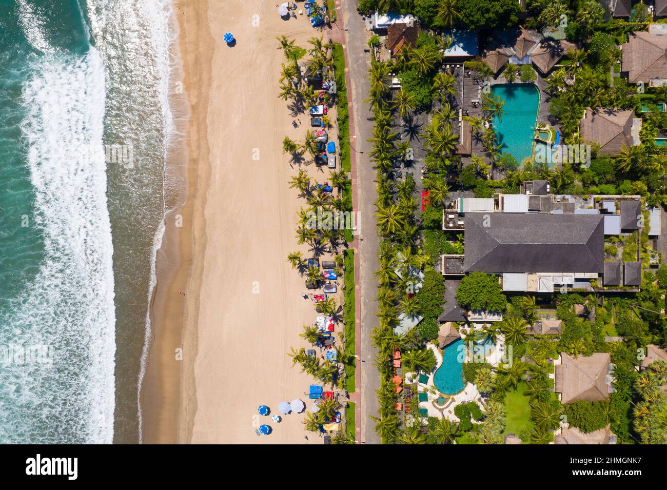 Vista de arriba abajo de la famosa playa de Kuta en Seminyak en el sur de Bali con un lujoso complejo frente al mar en Indonesia Foto de stock