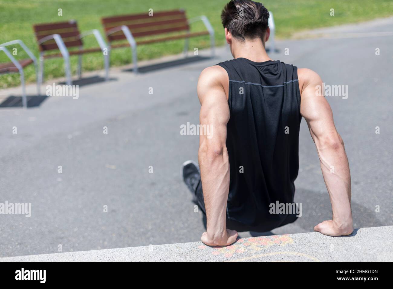 Hombre fuerte que trabaja los músculos de los brazos haciendo triceps