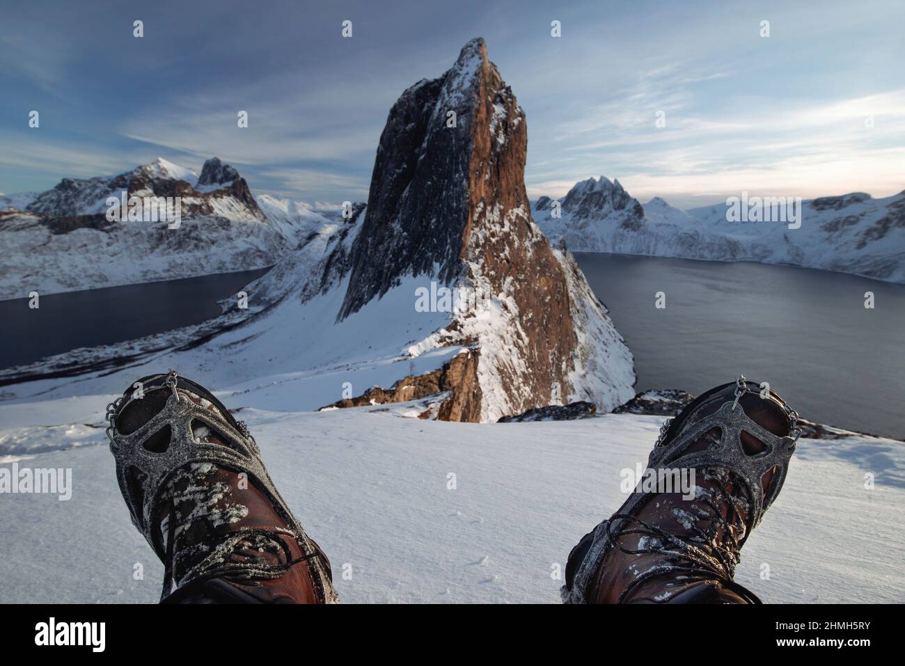 Primer plano de botas de montaña con crampones y polainas de nieve con  rayos de sol de contraluz y brucas nevadas en el fondo Fotografía de stock  - Alamy