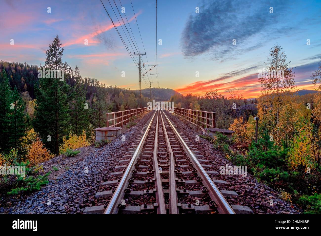 Puente de ferrocarril y la montaña durante el sol hacia abajo Foto de stock