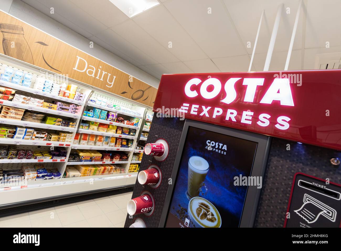 Dentro de una tienda local de Sainsbury en el Reino Unido, mostrando una máquina de café Costa beide los productos lácteos Foto de stock