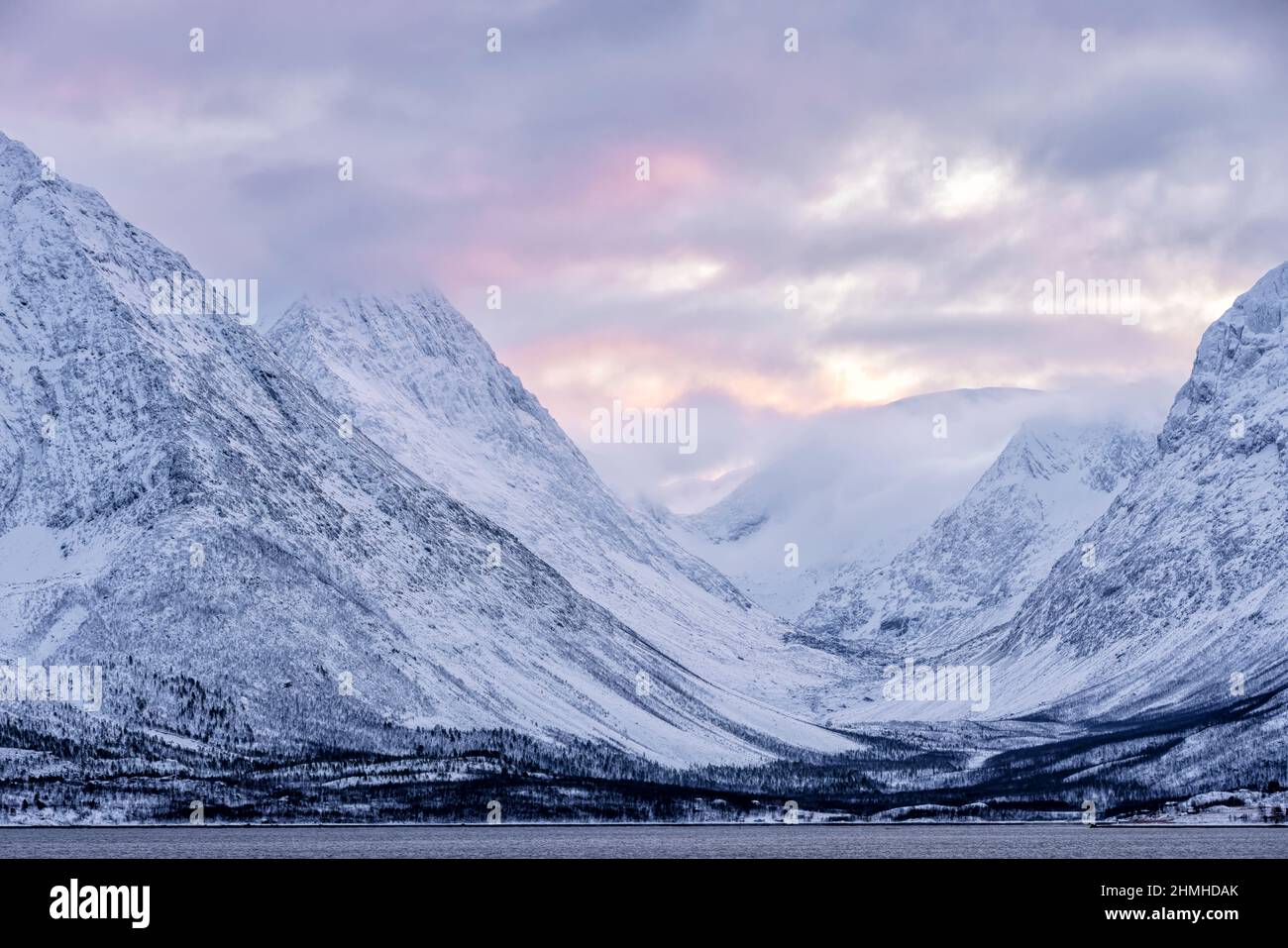 Paisaje nevado con nubes rojas justo antes de la puesta de sol Foto de stock