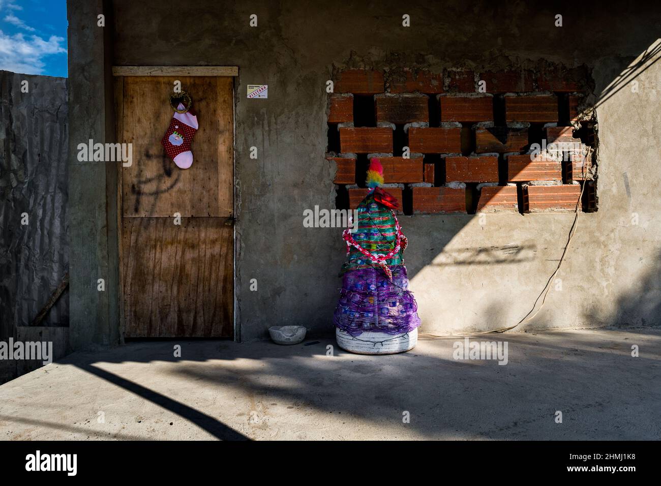 Un árbol de Navidad, hecho de materiales reciclados, se ve colocado frente a una casa familiar en Olaya Herrera, un barrio de baja clase social en Cartagena. Foto de stock