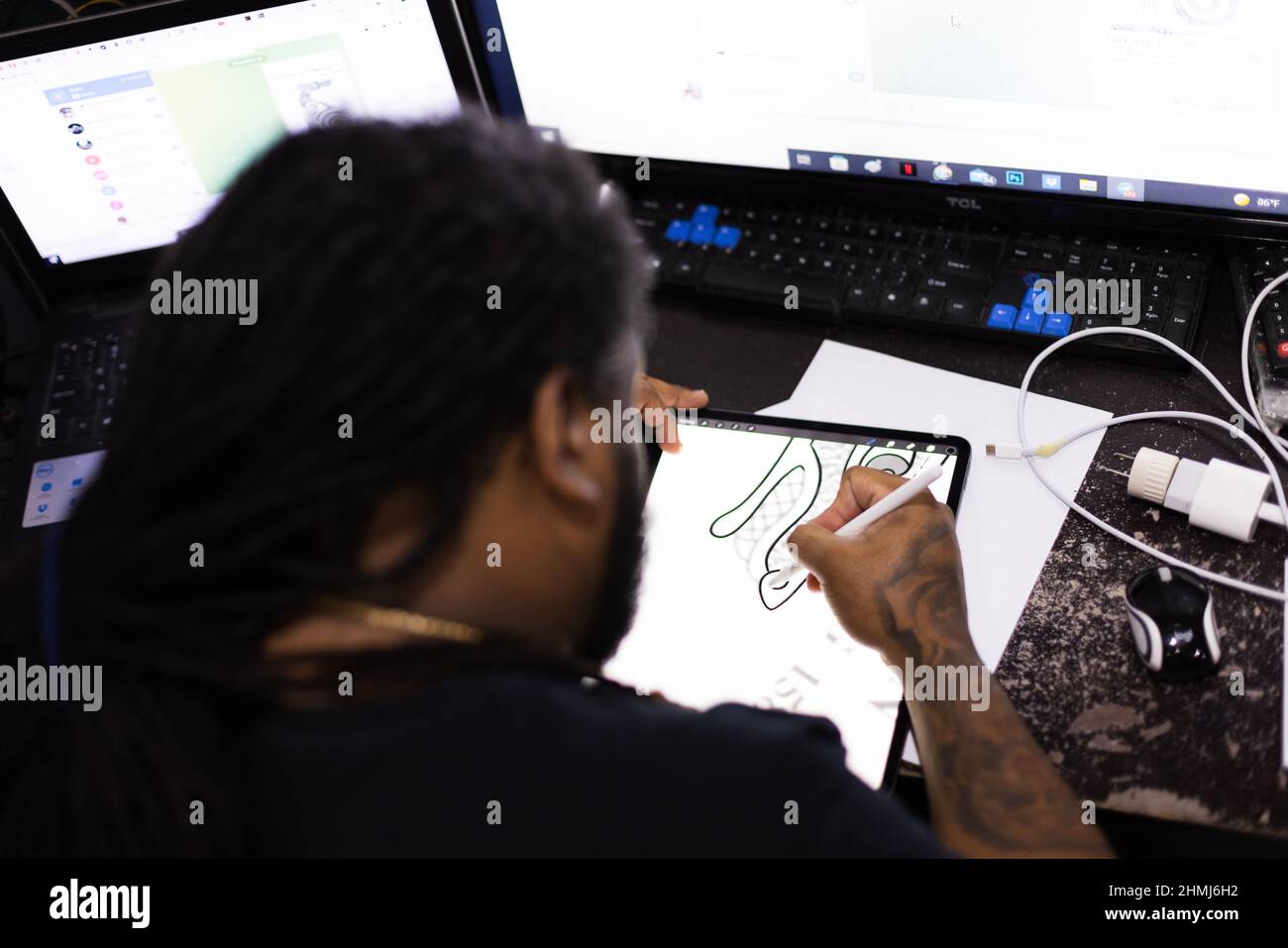 Hombre dibujando en una tableta. Vista trasera. Enfoque selectivo. Foto de stock