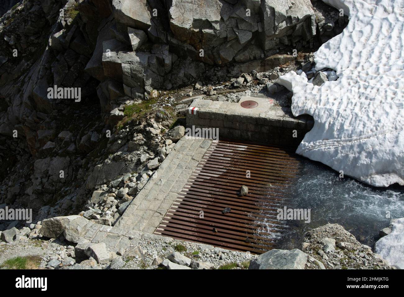 Ein Bach im Berner Oberland verschwindet in einer Wasserfassung zur Stromproduktion Foto de stock