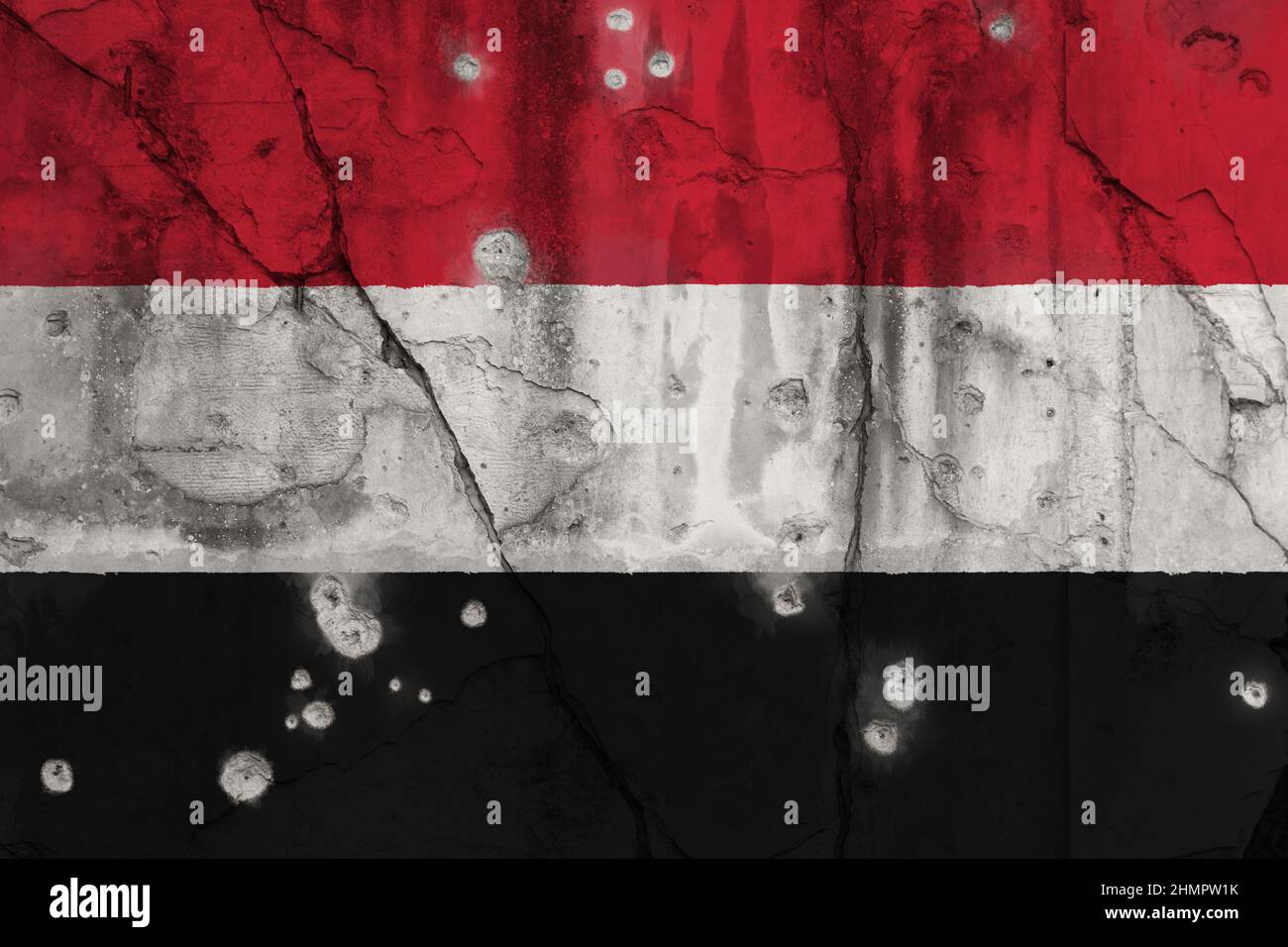 Foto de marco completo de una bandera desgastada de Yemen pintada en una pared agrietada con agujeros de bala. Concepto de crisis yemenita y guerra civil. Foto de stock