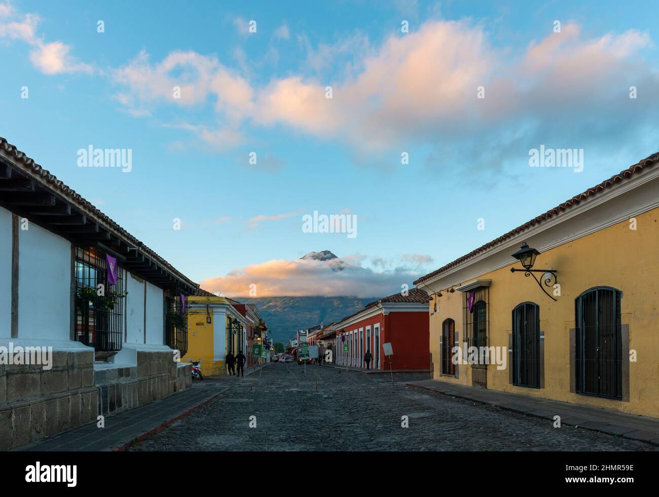 Antigua calle de la ciudad al amanecer con el volcán Agua, Guatemala. Foto de stock