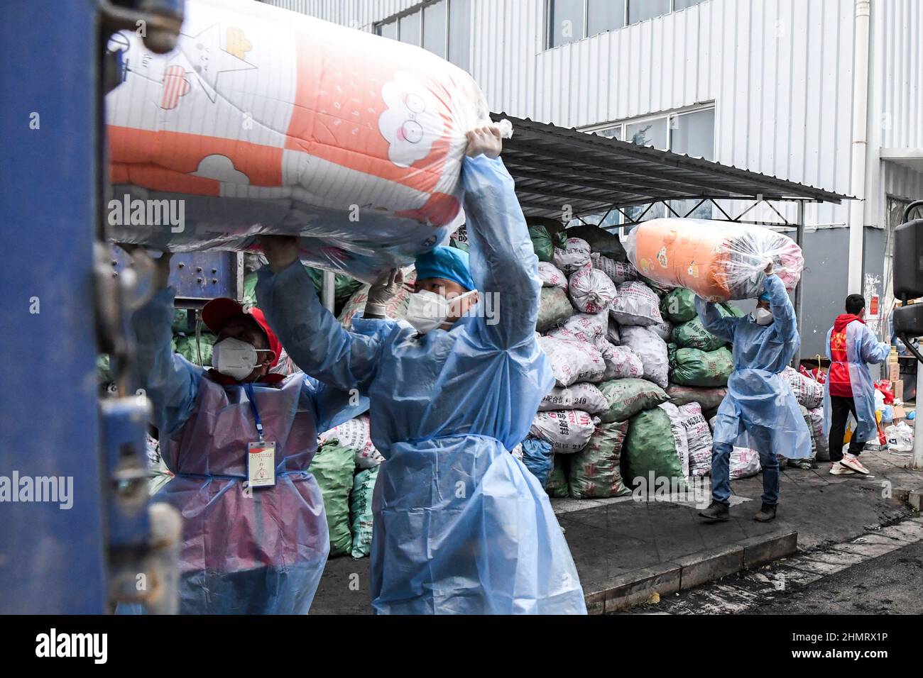 Debao, Región Autónoma de Guangxi Zhuang, China. 11th Feb, 2022. Los trabajadores cargan edredones para el personal de primera línea en el condado de Debao de la ciudad de Baise, región autónoma de Guangxi Zhuang, al sur de China, 11 de febrero de 2022. Los materiales vivos y médicos han sido entregados continuamente a Debao para ayudar a la lucha contra el reciente resurgimiento de la pandemia COVID-19 en el condado. Crédito: Cao Yiming/Xinhua/Alamy Live News Foto de stock