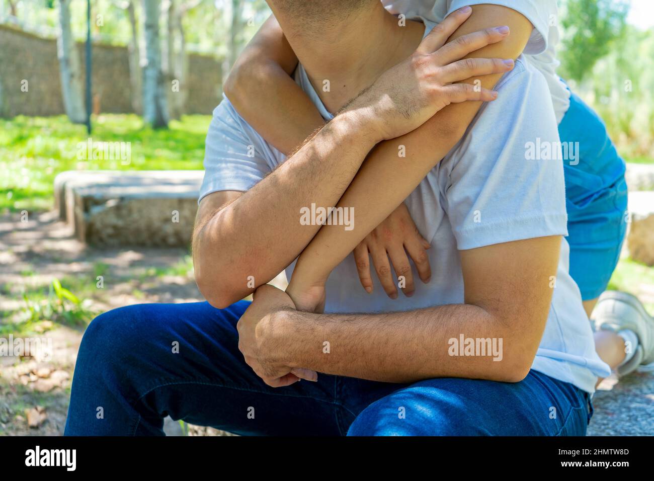 Una mujer abrazando al hombre desde atrás en un parque. Ella pareja irreconocible en amor y feliz. Concepto de amor, pareja, felicidad. Foto de stock