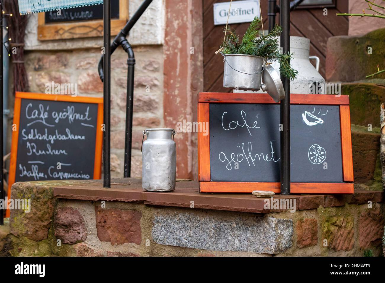 pizarra con el mensaje escrito a mano con las palabras alemanas para café abierto en frente de un pequeño restaurante en un casco antiguo alemán. Foto de stock