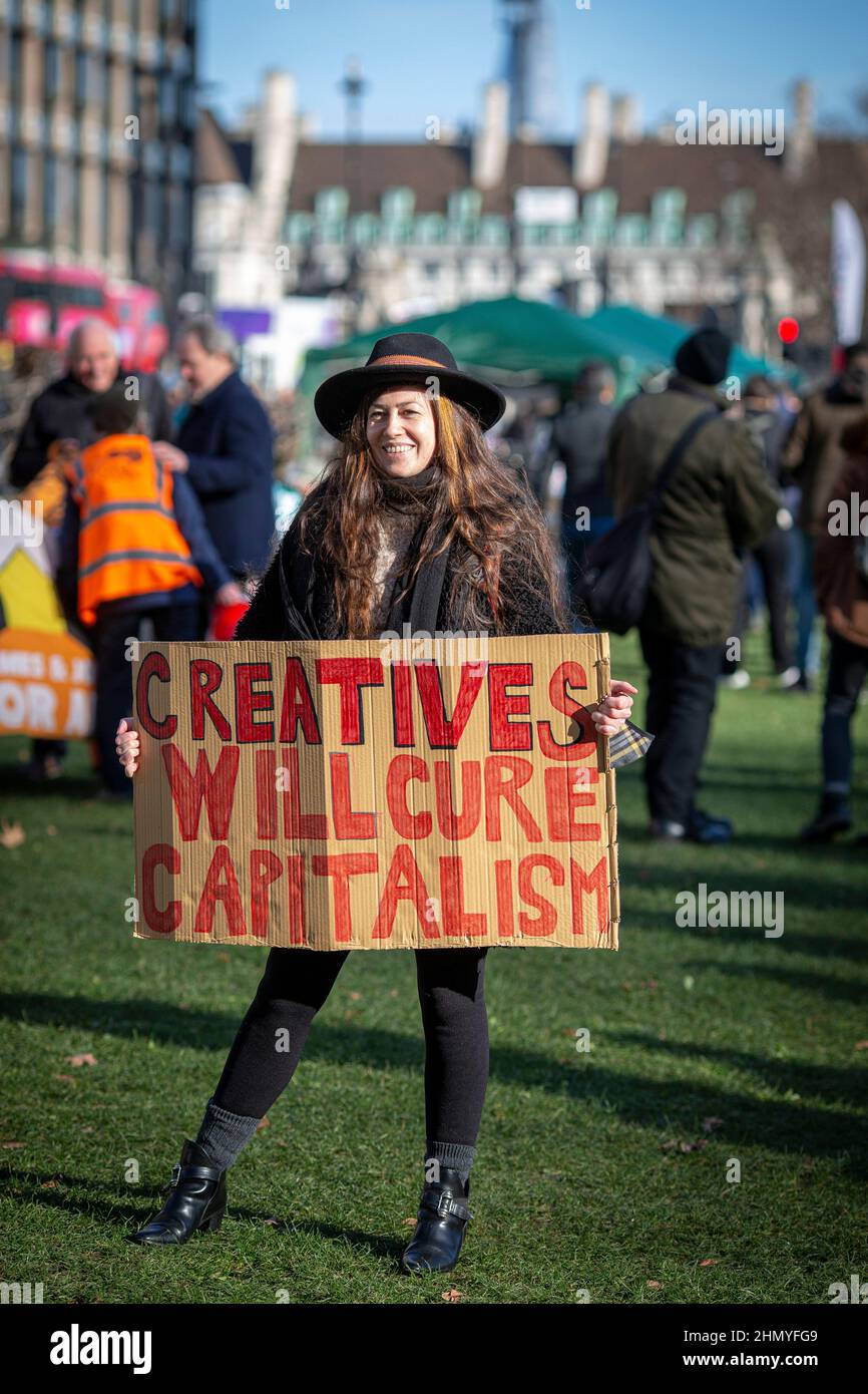 LONDRES, REINO UNIDO - 2022/02/12: Un manifestante tiene un cartel que dice que los creativos curarán el capitalismo durante la manifestación. Foto de stock