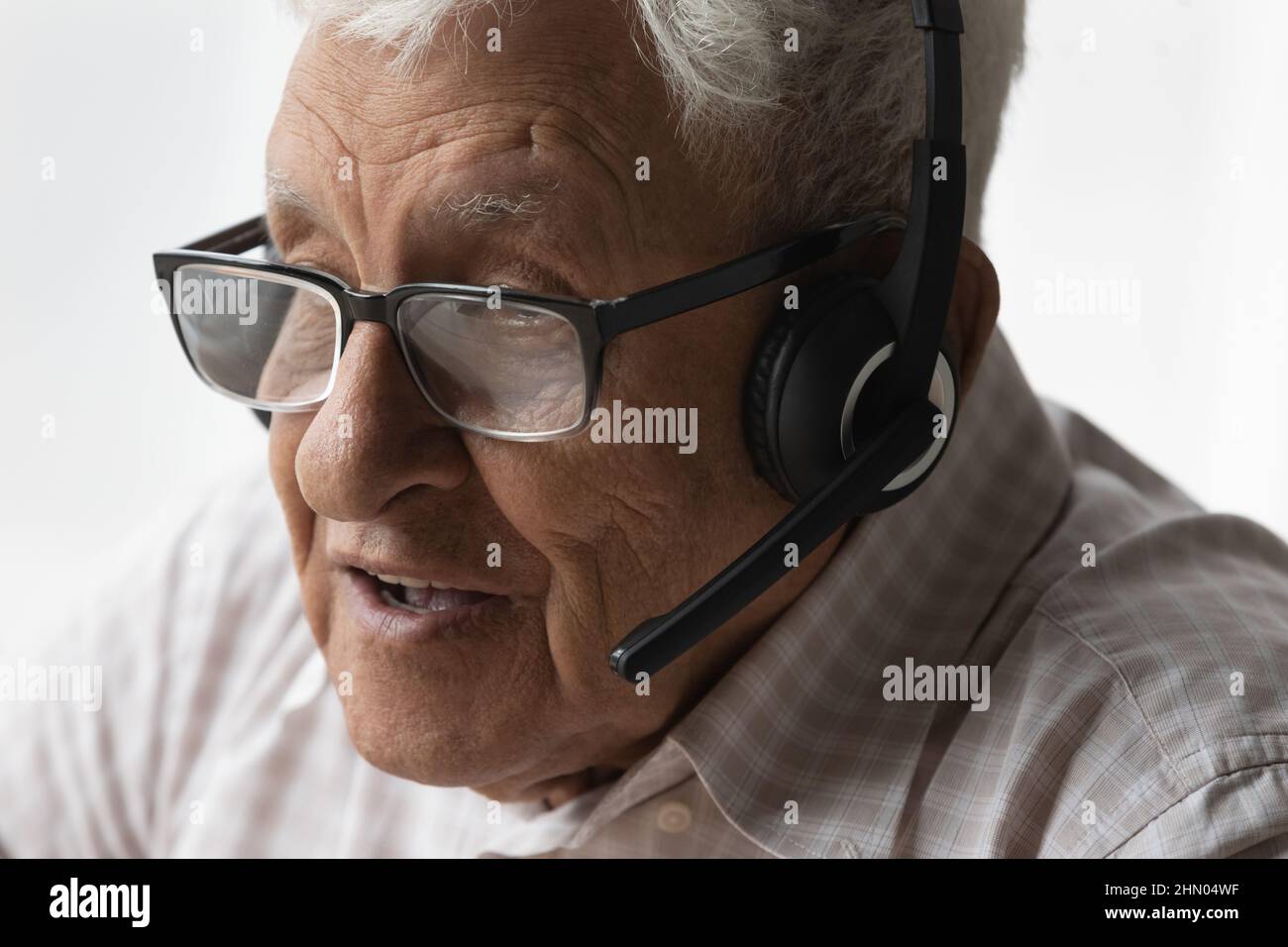 Cara del anciano en los auriculares hablando en el micrófono Foto de stock