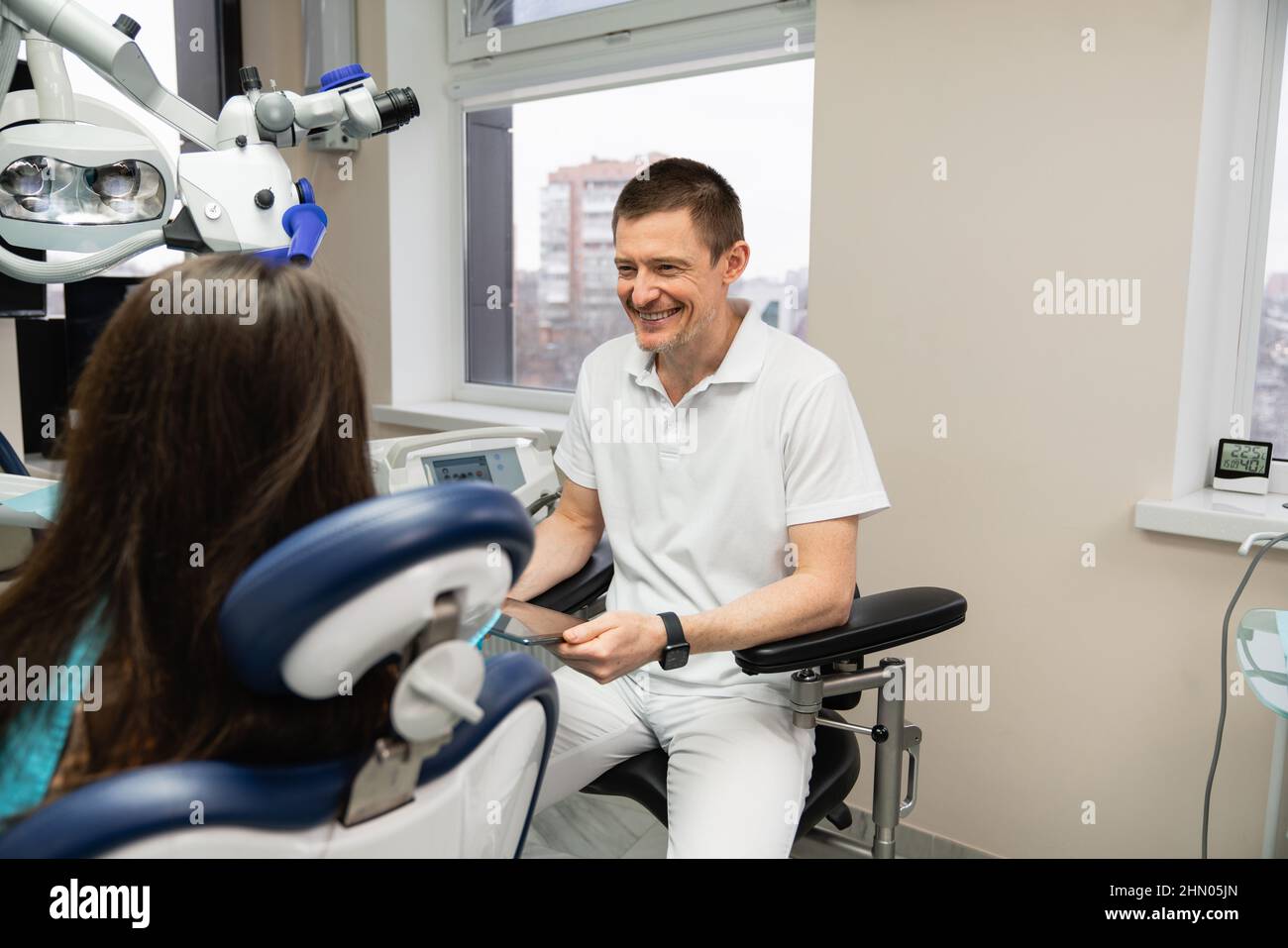 El dentista se comunica con el paciente en el consultorio dental