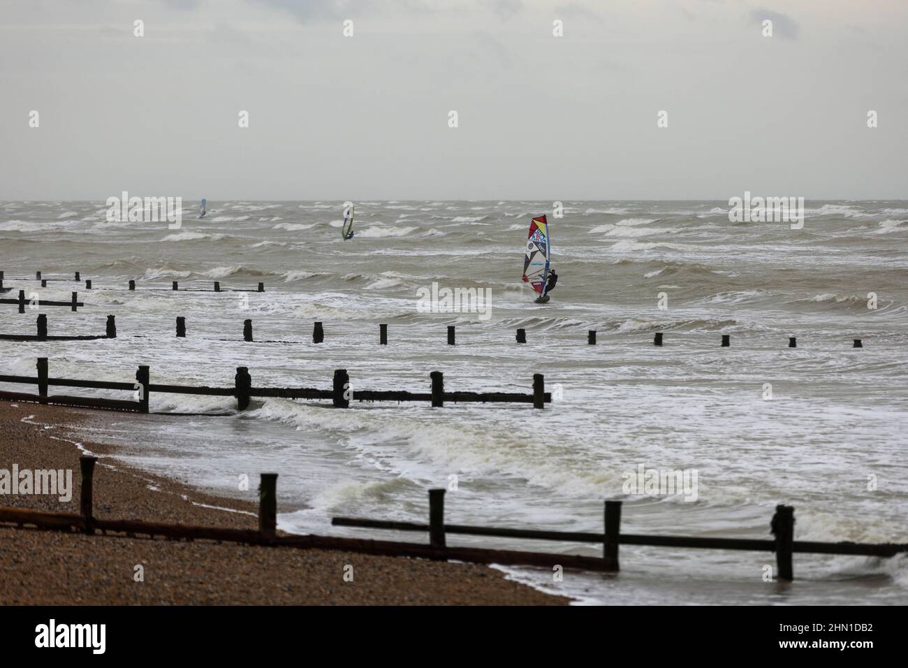 East Preston, Reino Unido, 13th de febrero de 2022. Kitesurfistas en el agua durante algunos fuertes vientos en la playa East Preston en West Sussex. Crédito: Steven Paston/Alamy Live News Foto de stock