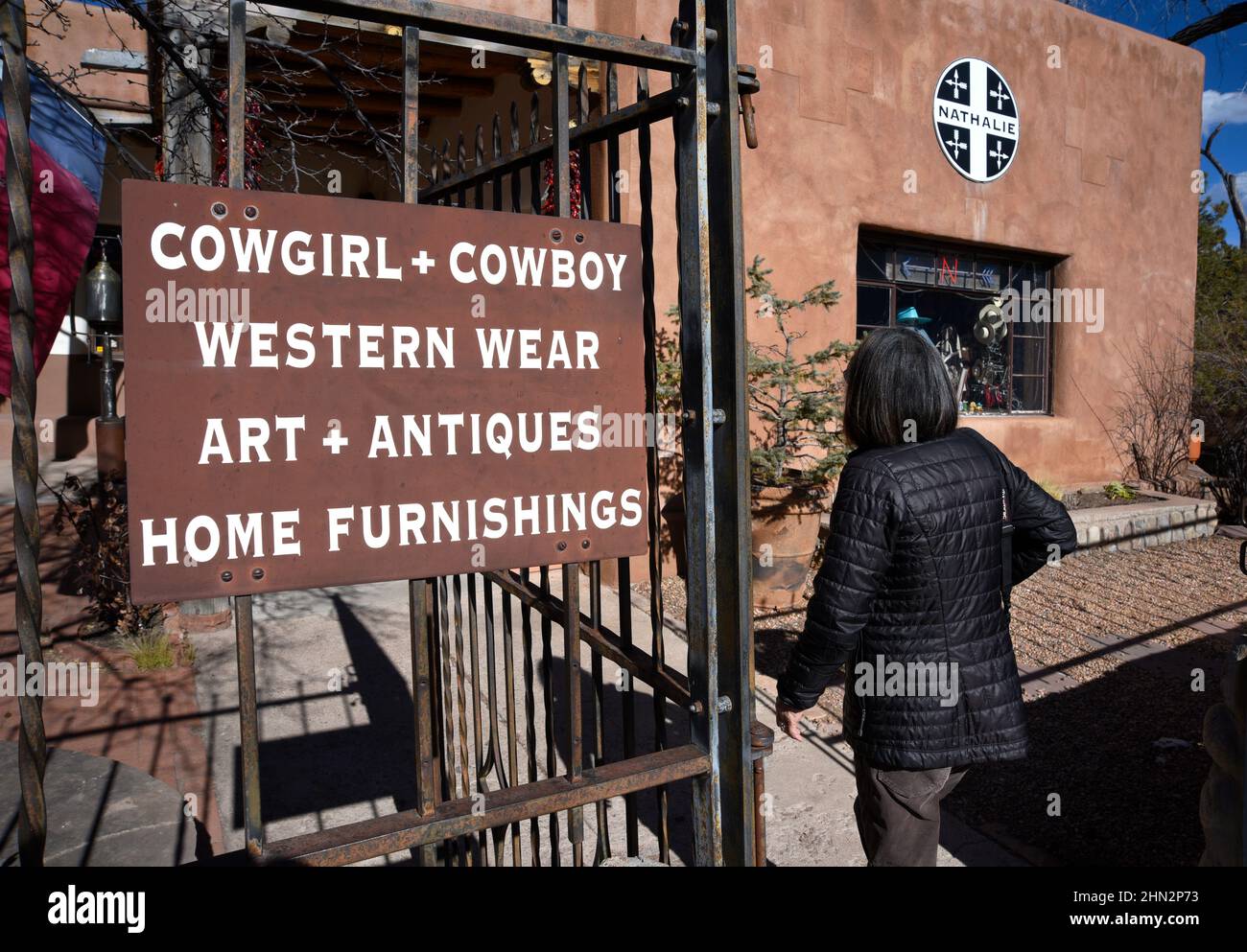 Una mujer entra en una tienda occidental de ropa, arte y antigüedades en Santa Fe, Nuevo México. Foto de stock