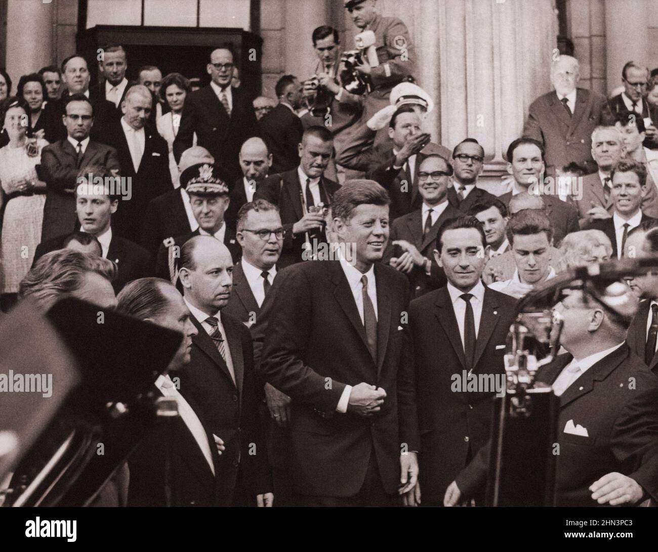 Foto vintage de la crisis de Berlín de 1961: Construyendo el Muro. Acompañado por funcionarios locales, el Presidente Kennedy abandona la Kurhaus de Wiesbaden, donde él Foto de stock