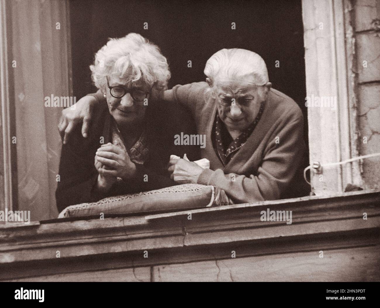 Foto vintage de la crisis de Berlín de 1961: Construyendo el Muro. Dos mujeres en el lado oriental del muro de Berlín muestran sus emociones de anhelo de libertad Foto de stock