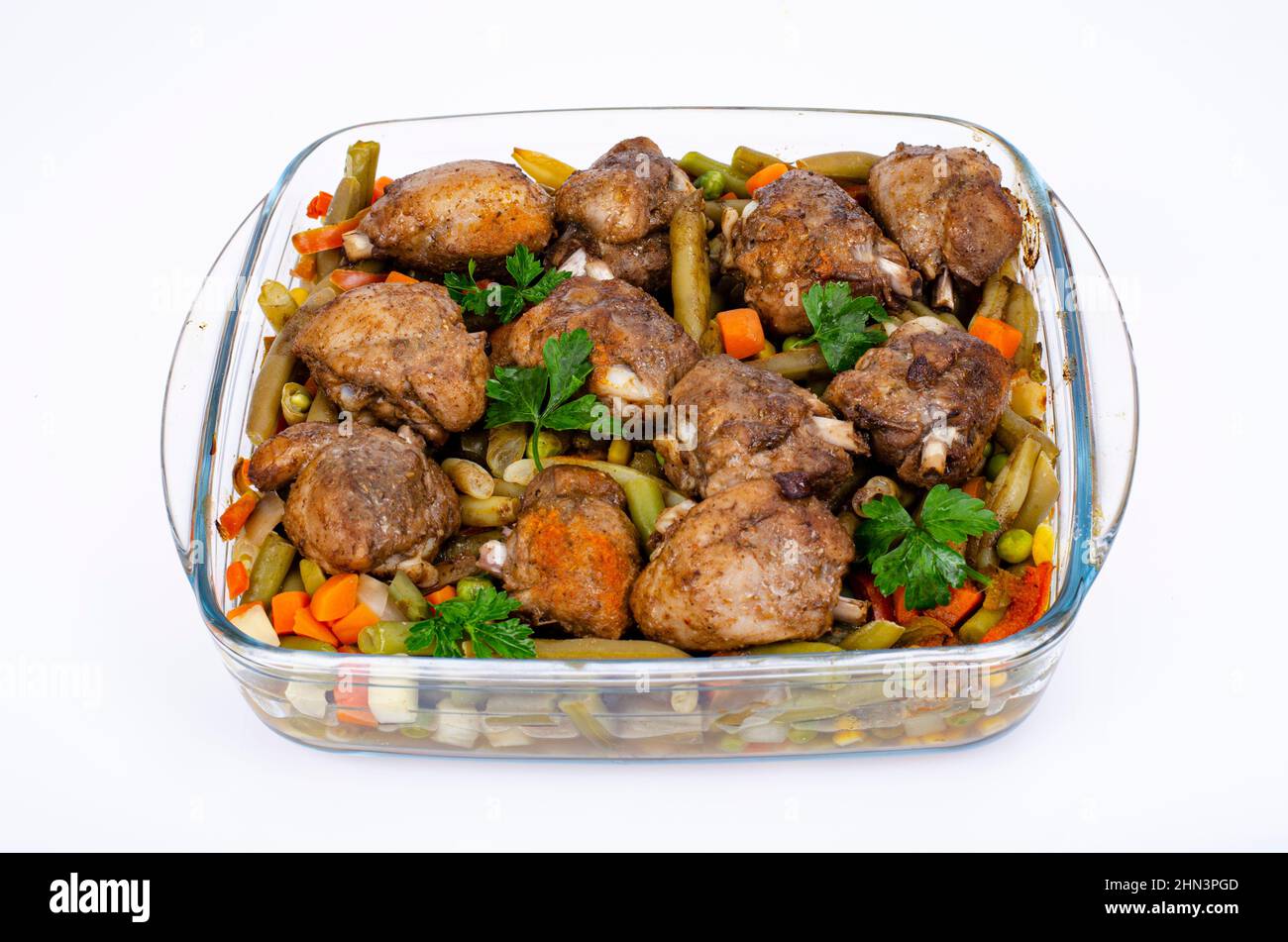 Plato de cristal con verduras al horno y trozos de pollo. Foto de estudio  Fotografía de stock - Alamy