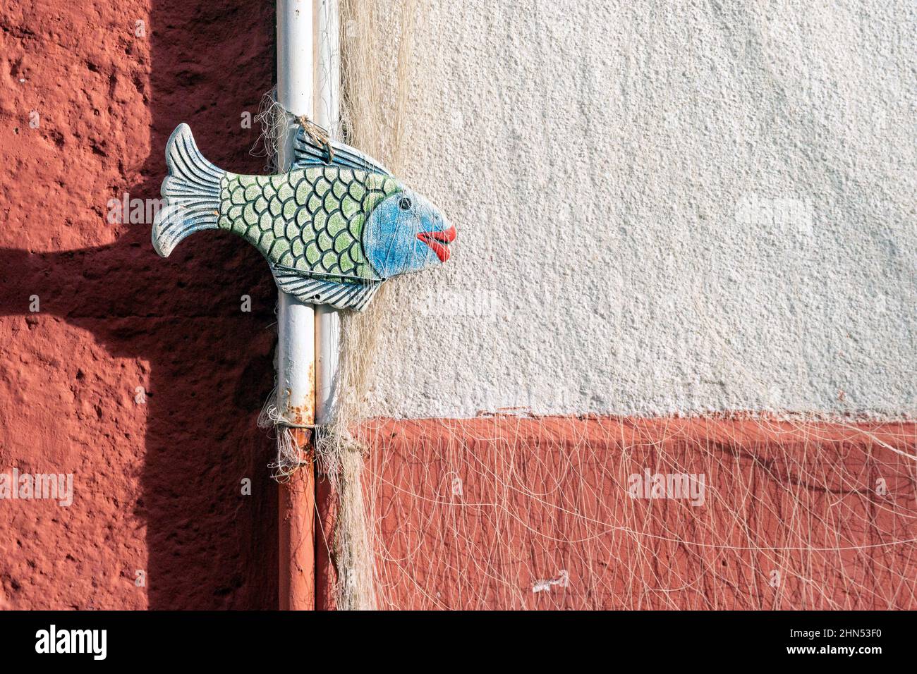 Peces de arte callejero con labios rojos unidos con una pipa Foto de stock