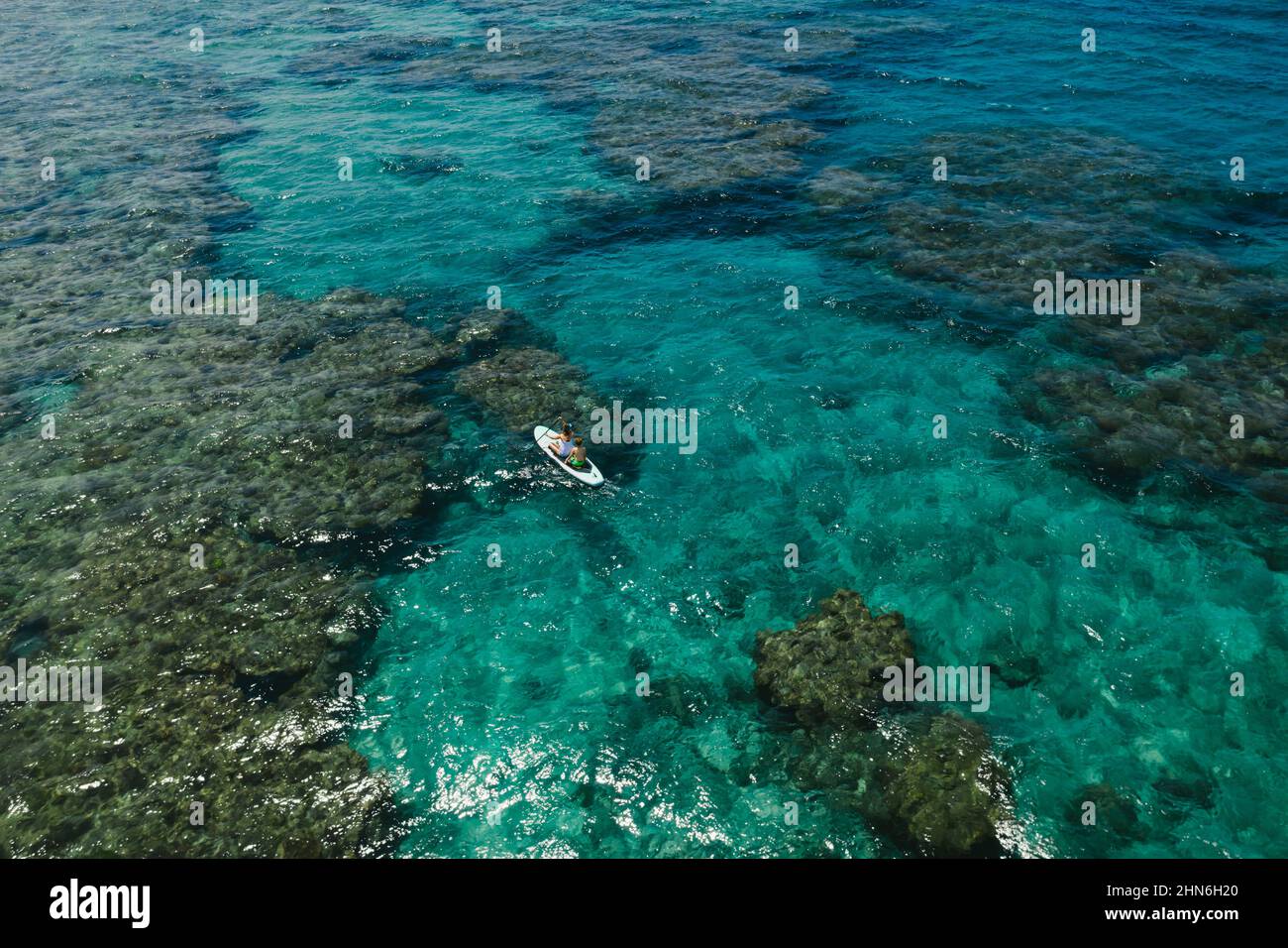 Se estancaría en Paddle Boarding sobre los arrecifes de coral en el Mar de China Oriental Foto de stock