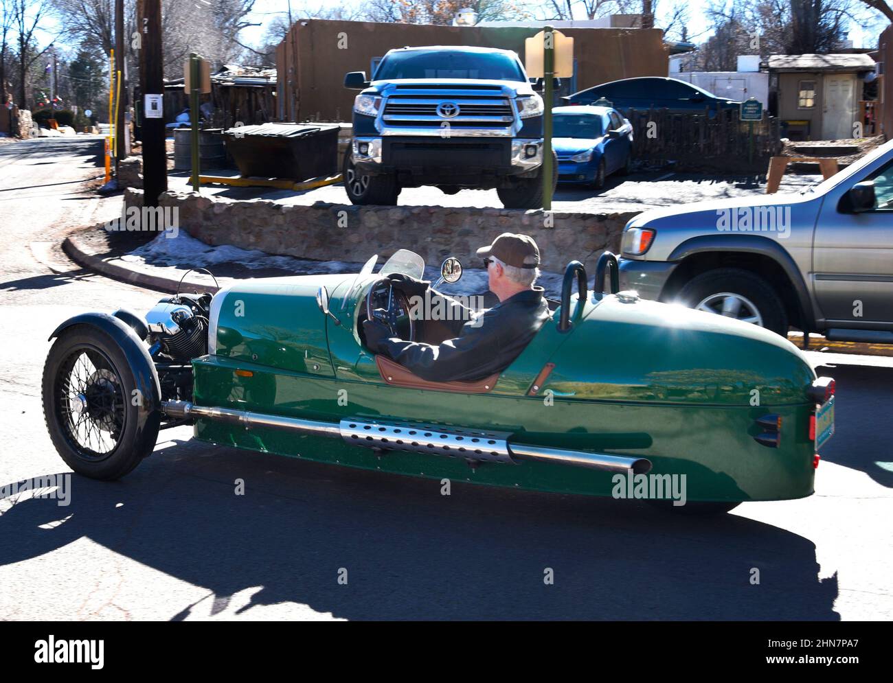 Un hombre conduce un coche deportivo Morgan de 3 ruedas a lo largo de una carretera en Santa Fe, Nuevo México. El único coche es hecho por la Morgan Motor Company en Inglaterra. Foto de stock